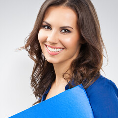 Portrait of young happy smiling businesswoman with blue folder, with blank copyspace area for...