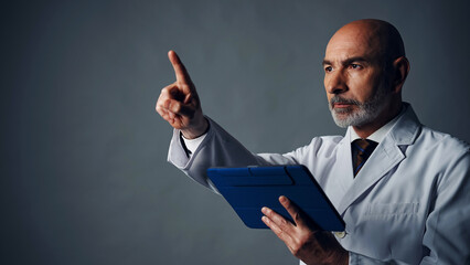 Middle-aged white man in a lab robe operating stereoscopic image with tablet PC. - Powered by Adobe