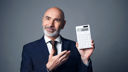 Middle-aged white man in a suit showing a calculator. Sales person.
