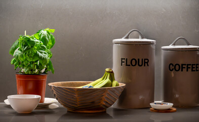 Kitchen flour and coffee canisters with bowl of bananas and fresh pesto plant