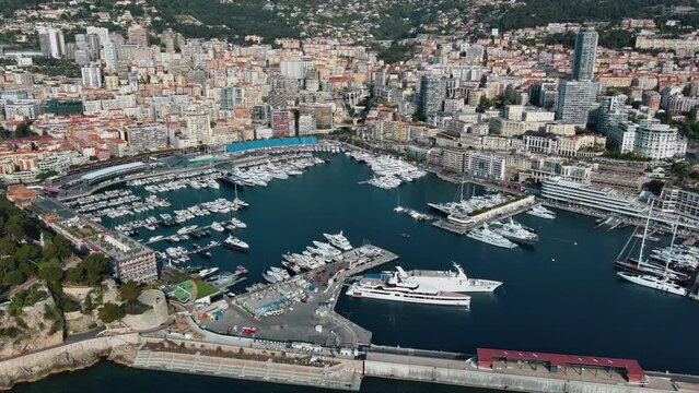 Panoramic view of La Condamine ward and Port Hercules in Monaco-Ville, Cote d'Azur ft. World Fair MYS Monaco Yacht Show in Monte Carlo with luxury yachts and boats are in marina, Mediterranean Sea 4K