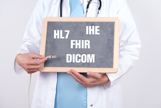 Arzt mit einer Tafel auf der HL7 DICOM IHE und FHIR steht. Konzept medizinische Standards in der IT