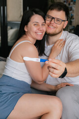 happy couple looking at positive pregnancy test