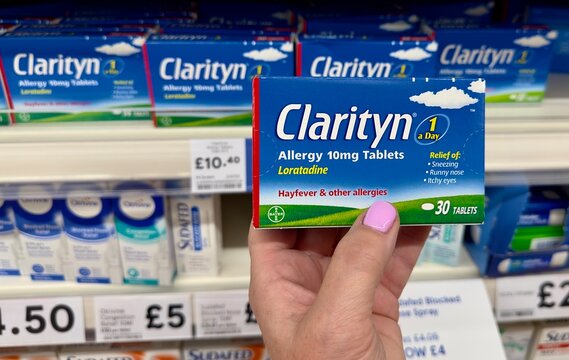Essex, UK - July 24, 2023: A box of Clarityn loratadine hayfever and allergy tablets being held up in front of the medication section of a Tesco supermarket. 