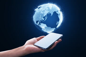 Close up of female hand holding cellphone with glowing globe hologram on blurry blue background. Digital earth and metaverse concept.