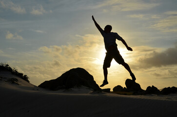 Jumping Man Reaching for the Stars at Sunrise