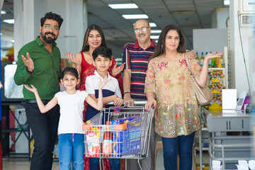 Indian family standing together at grocery shop.