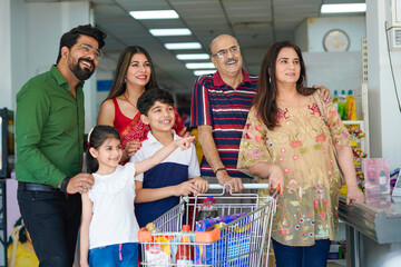 Indian family standing together at grocery shop.