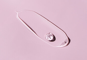 cosmetic smear round drops of transparent gel serum on pink background
