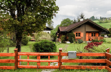 wooden house with a fence and a wonderful garden in a nature landscape