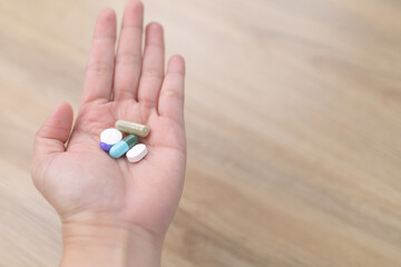 Top view of a lot of pills and tablets in the hand, consuming a lot of pills concept. medicine in old man hand. The concept of medicine, health care, vitamins. background with space for text.