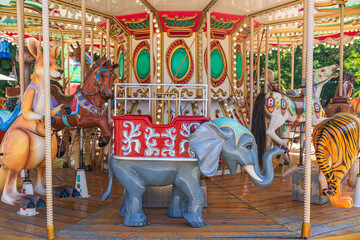 Carousel in an amusement park. Merry go round. The concept of summer holidays and school holidays
