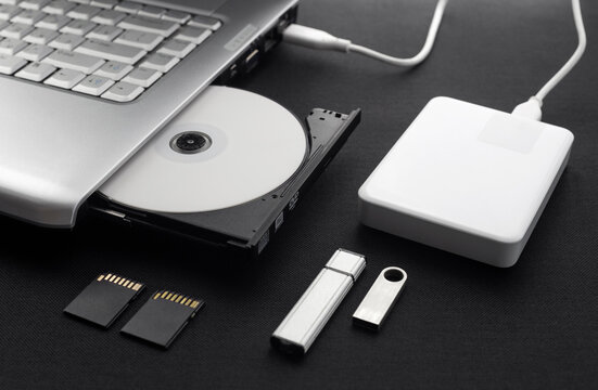 data storage devices connected to a laptop, data security, digital data storage, laptop open optical drive with disk