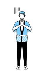 体の前で手を合わせて謝る夏祭りの法被を着た男性