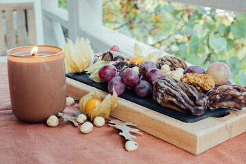 Hello autumn. Cozy fall still life with candle and fruits. Cute balcony scene.