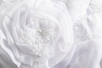 Soft airy fabric flower close-up. details of the bride's wedding white dress. Wedding background....