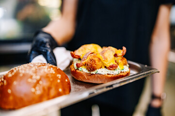 chef hand cooking cheese burger with vegetables and meat on restaurant kitchen