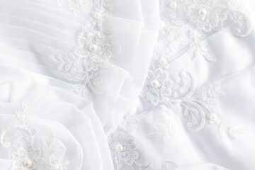 The fabric details of the bride's dress, the beautiful embroidery and drapery. white airy folds of...