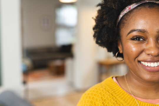 Portrait of happy african american woman wearing yellow sweater smiling, copy space