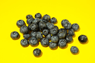 Colorful blueberries on yellow background. Top view. Flat lay