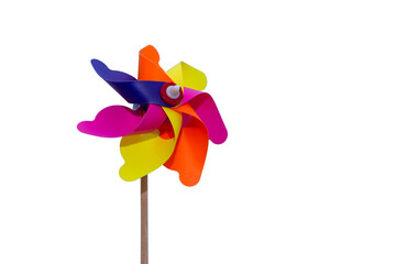Colorful windmills on isolated white background in selective focus. Windmills with wings of different colors. Clean energy, LGBTQ colors concept. - obrazy, fototapety, plakaty