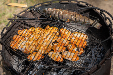 Grill with chicken and fish being grilled