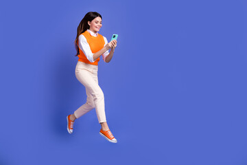 Fototapeta premium Full length photo of carefree jumping woman brunette hair wear formal uniform browsing smartphone sale isolated on purple color background