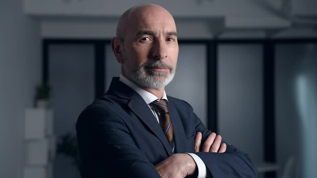 Middle-aged white man in a suit smiling in the office. Facial expression.