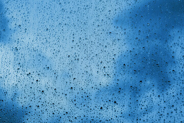 Fototapeta na wymiar raindrops on the window with dark clouds in the background