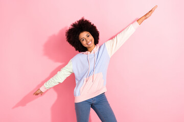 Portrait of cheerful positive schoolchild beaming smile arms wings have good mood isolated on pink color background