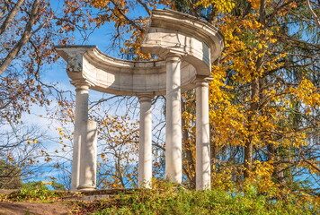 Ruins of an ancient rotunda gazebo in an autumn park on a sunny day