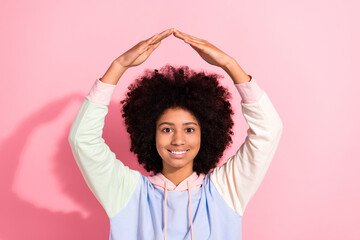 Portrait of cute positive schoolkid beaming smile arms demonstrate roof above head gesture isolated...