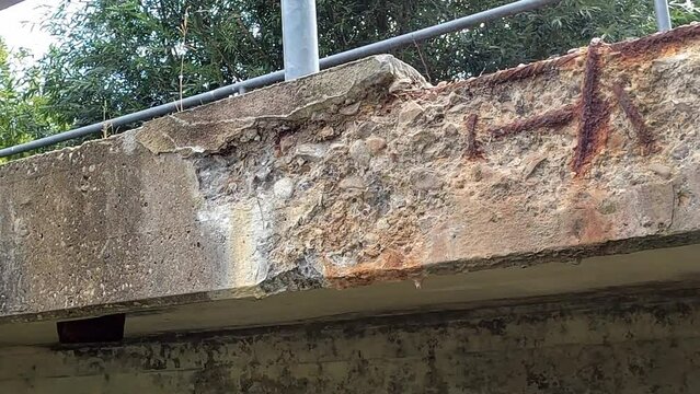 Rusty structural steel and flaking concrete parts on a bridge