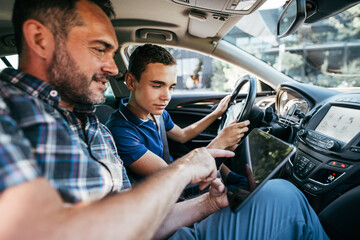 Driving instructor sitting his student and explain to him car driving basics, how to properly...