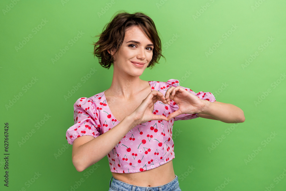 Poster Photo portrait of attractive young woman show fingers heart shape wear trendy pink cherry print clothes isolated on green color background