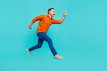 Fototapeta na wymiar Full body size side cadre running hurry inspired businessman pensioner wear orange shirt blue jeans isolated over cyan color background