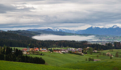 Fototapeta premium houses at the foot of the mountain with magnificent morning fog.