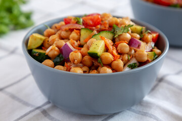 Homemade Avocado Chickpea Salad with Chili Lime Dressing in a Bowl, side view. Close-up.