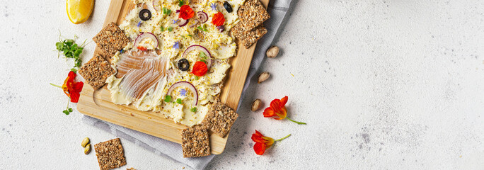 Spread butter and herbs on wooden board. Trendy appetizer food. Long banner