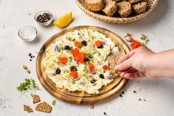 Woman hand takes butter with herbs from wooden board. Trendy appetizer food