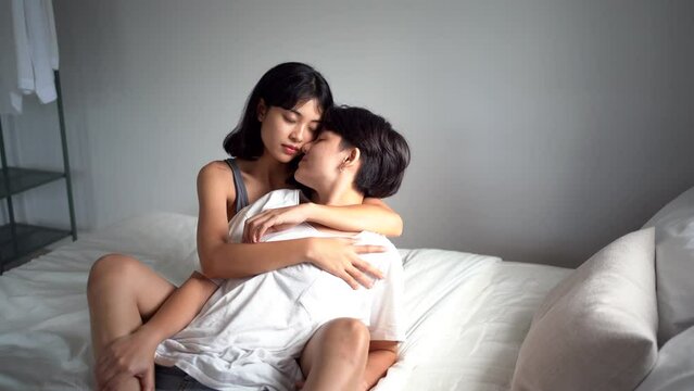 Y young Korean couple kissing and making out with each other in the bed in the morning just after they have woken up