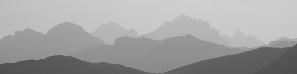 Black and white image of mountain peaks in the morning light seen from Vorder Walig, Switzerland.