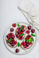 Fresh bread sandwiches with sweet cherry, cream cheese and mint leaves. Morning breakfast concept