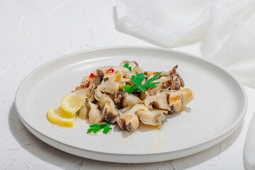 Rapana clam meat with oil, spices and greens. Healthy seafood is rich in omega. Marine decor