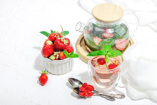 Strawberry tea concept. Good morning concept. Teapot, ripe fruits, healthy beverage