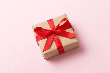 Wrapped christmas or other holiday handmade present in craft paper with colored ribbon. Present box, decoration of gift on table, top view with copy space
