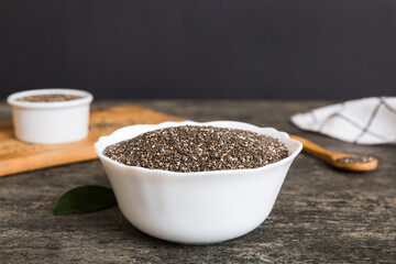 Chia seeds in bowl and spoon on colored background. Healthy Salvia hispanica in small bowl. Healthy superfood