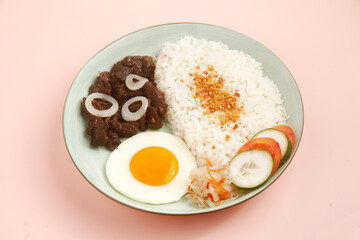 Photo of freshly cooked Filipino food called TapSilog or beef tenders served with fried rice and egg.