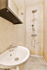 a bathroom with a sink and shower head mounted on the wall next to an open shelf above it that holds a mirror
