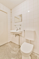 a bathroom with a white toilet and black and white tiles on the floor, in front of a shower stall